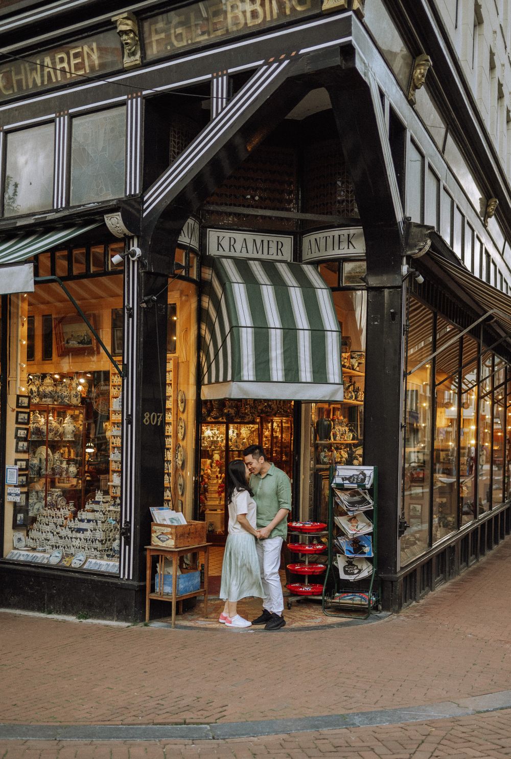 Historic storefront with striped awnings and shop windows displaying merchandise.