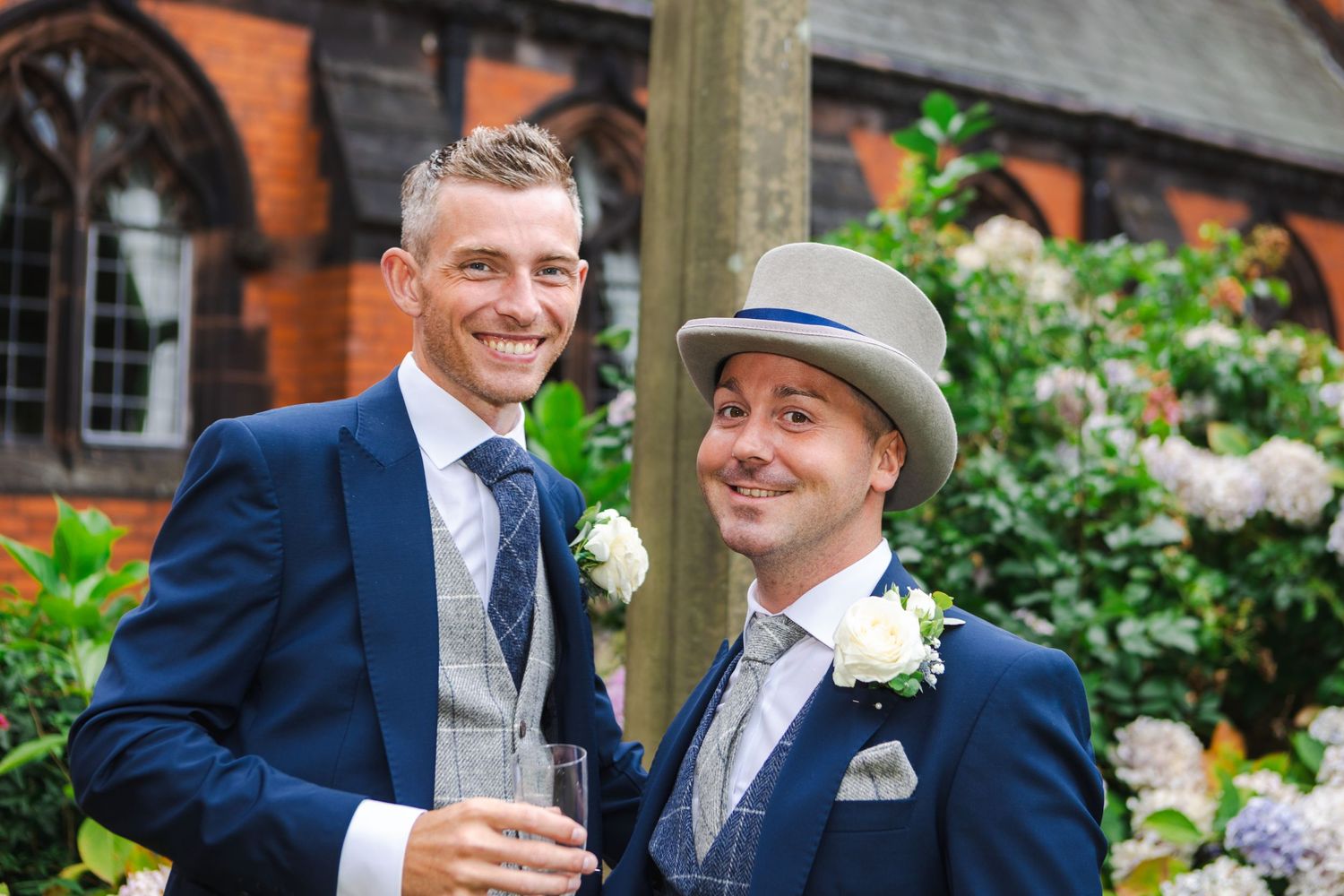 Celebratory scene at an outdoor wedding with navy suits and floral decor.