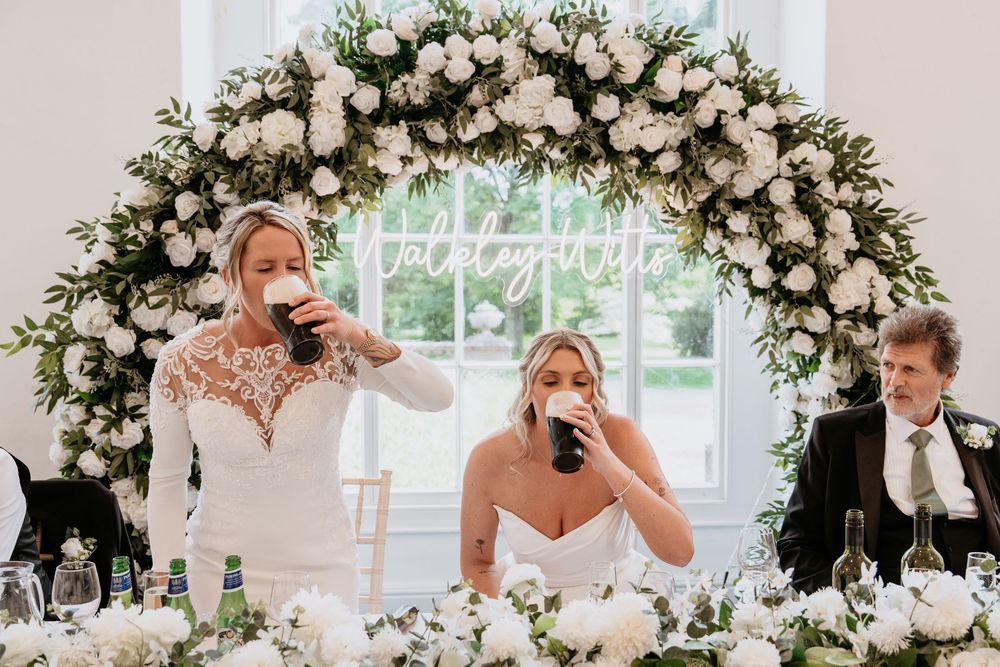A series of candid wedding moments at a reception decorated with elegant white floral arrangements.