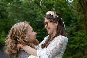 Bride and groom gaze into each others eyes in a woodland. Colourful Wedding Photography
