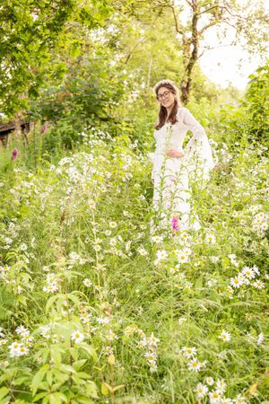Portrait of a bride standing among wild flowers in a woodland glade in Gwynedd, North Wales, UK. Pagan Handfasting photographer.
