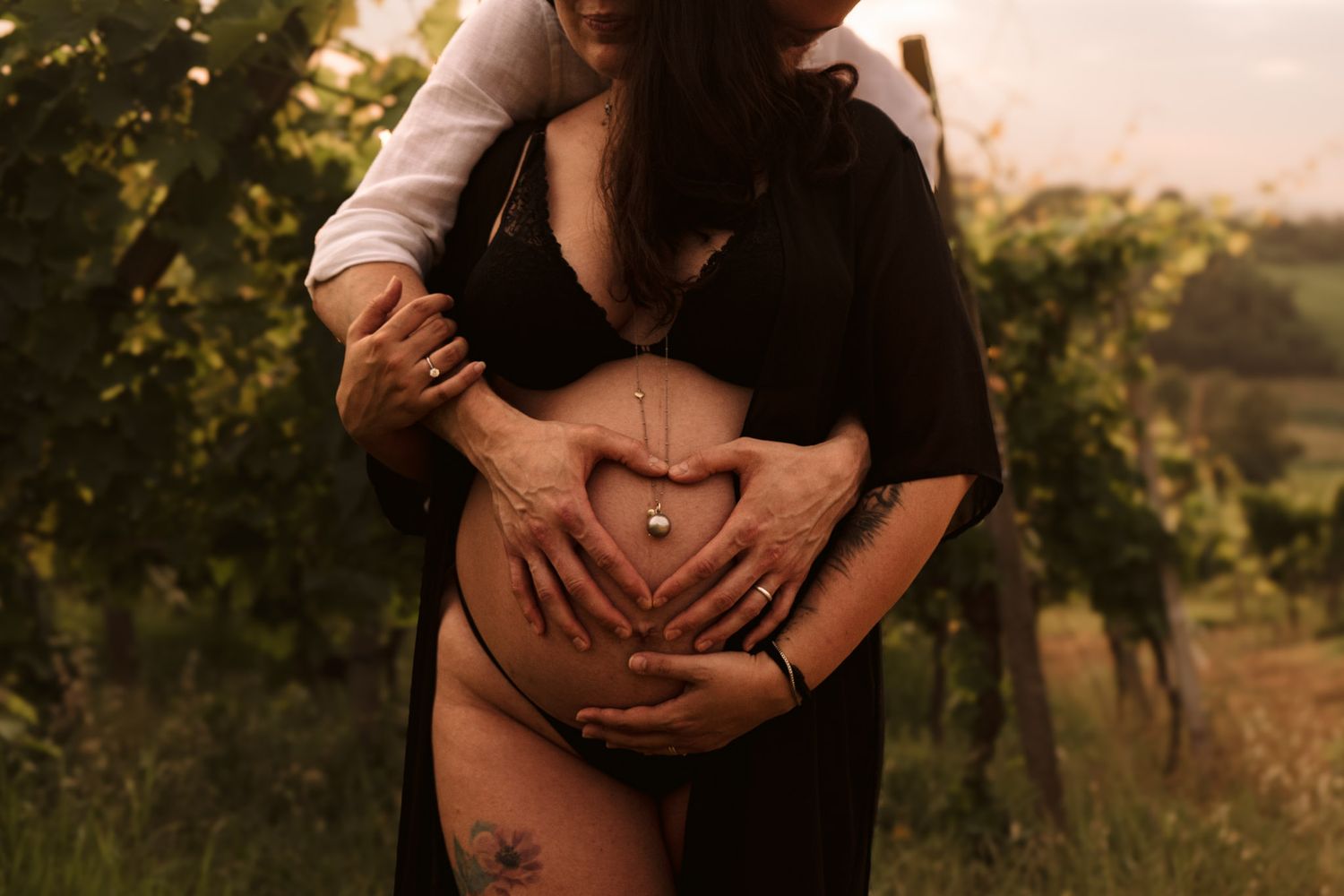 Servizio fotografico di maternità romantico al tramonto in un vigneto dorato con morbida illuminazione naturale. in provincia di Alessandria