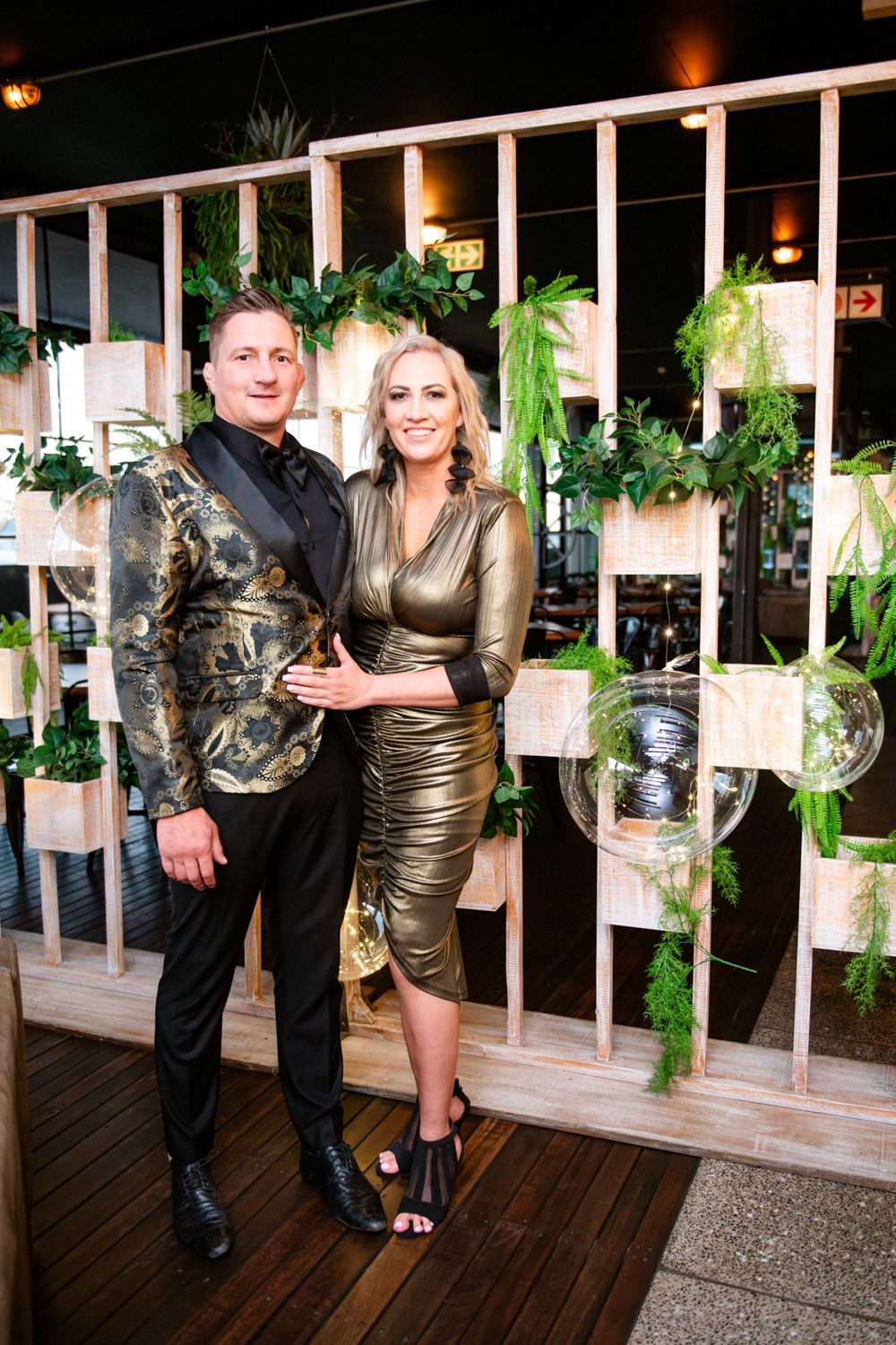 Events and Birthday parties photography, a couple wearing black and gold, posing at their birthday dinner.