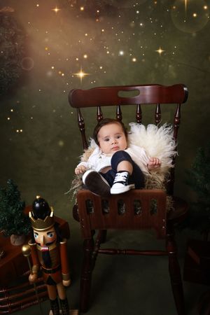 A magical holiday scene with nutcracker decorations and twinkling stars surrounding a wooden bench with white tulle.