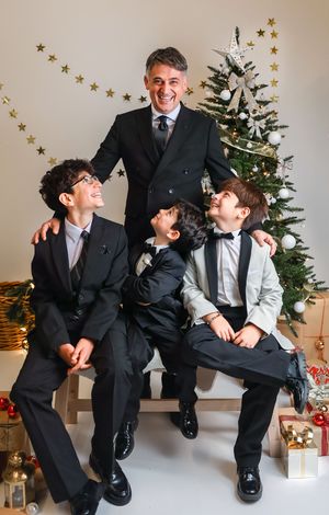 Four candid holiday photos showing playful poses in front of a decorated Christmas tree with gold stars.