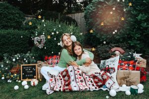 Cozy Christmas photo setting with presents, decorations and festive blankets in a garden.