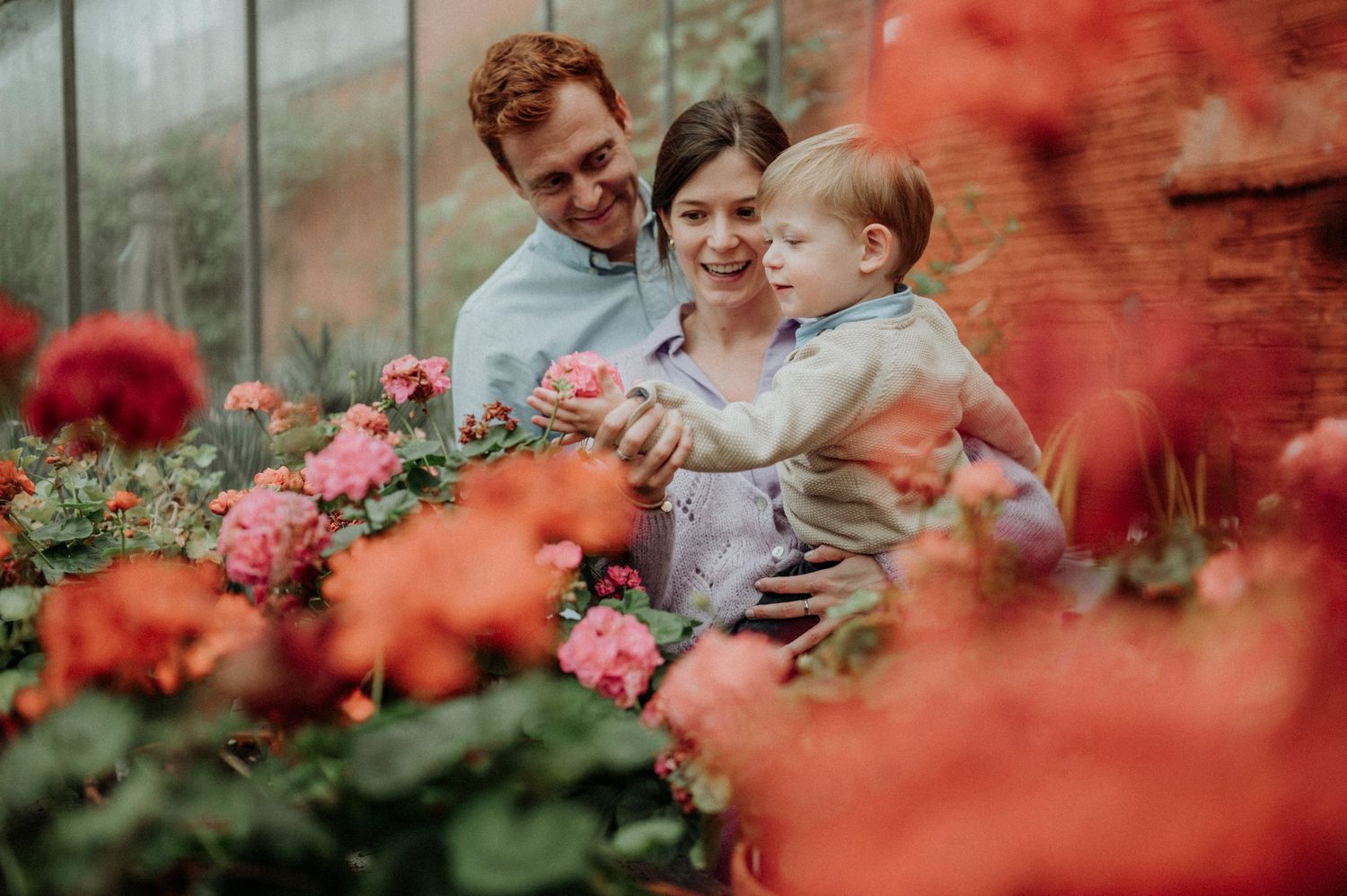 Een foto van een jong gezin met een zoontje tussen de bloemen in de Kruidtuin in Leuven.