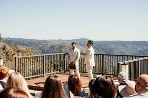 Scenic mountain vista visible through railing during an outdoor wedding ceremony.