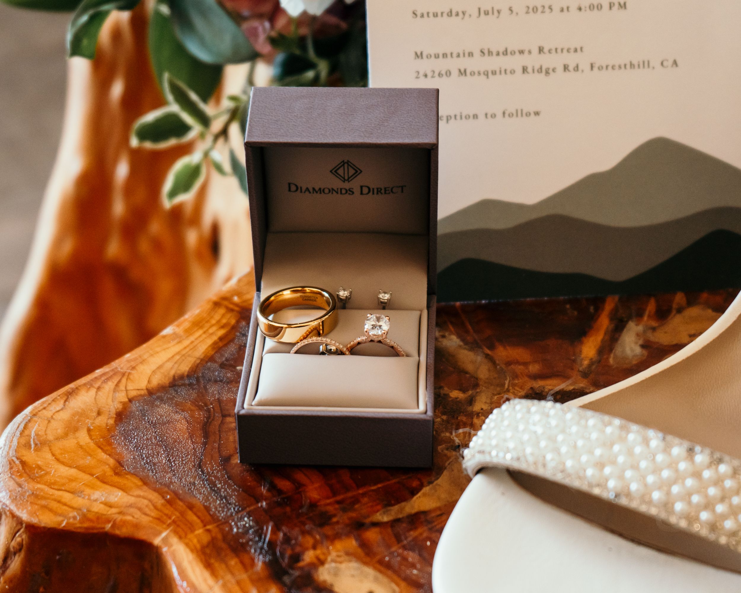 Wedding detail shots showing jewelry boxes and accessories arranged on a wooden surface.