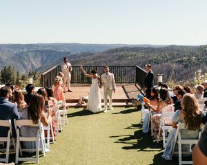 Panoramic view of outdoor wedding ceremony setup with mountain landscape backdrop.