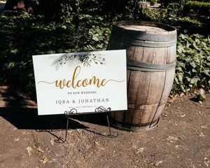 Rustic wooden barrel decor with welcome sign for wedding reception.