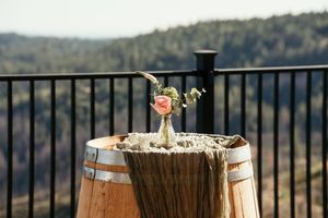 Scenic mountain view with rustic wine barrels and wedding decor on outdoor deck.
