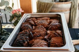 Freshly baked chocolate brownies cooling in metal baking pans with a fudgy, crackled top surface.