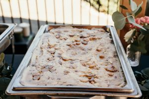 Wedding reception dessert table displays multiple trays of fresh baked treats.