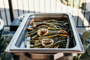 Catering tray filled with grilled vegetables and asparagus.