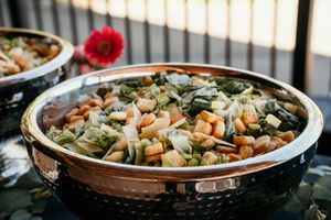 A large serving dish filled with mixed vegetables and beans in a copper-colored bowl.