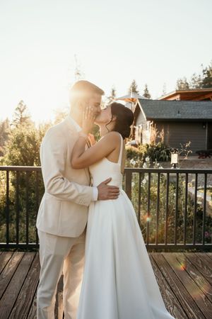 Romantic sunset moment on wooden deck with mountains in background.