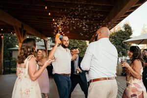 Wedding guests dance and celebrate together at an evening reception.