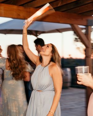 Wedding guests dancing and celebrating at an outdoor reception during golden hour.