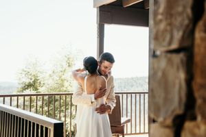Couple sharing romantic moments on an outdoor balcony with scenic views.
