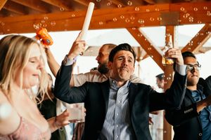 Wedding guests raising their hands in celebration during a reception party.