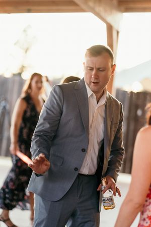 A series of candid dance moves showing someone in a gray suit jacket and white shirt at a celebration.
