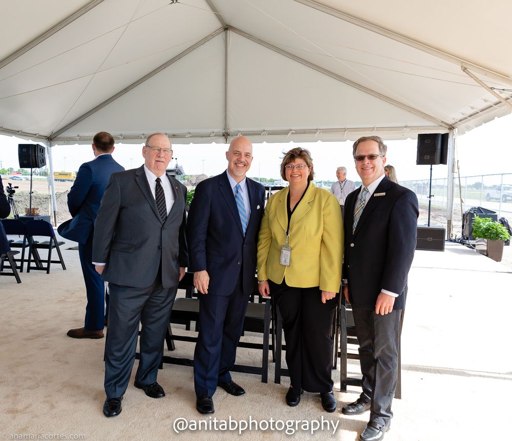 Group gathered under event tent for formal ceremony or presentation.
Ground braking event.