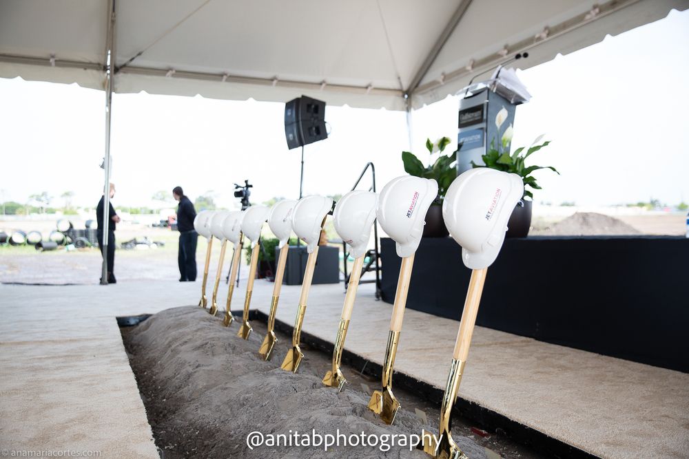 White ceremonial shovels lined up under an outdoor event tent. Ground braking event.