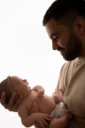 A parent in a beige sweater shares gentle moments with their newborn baby in a series of intimate black and white photos.NJ newborn photogra