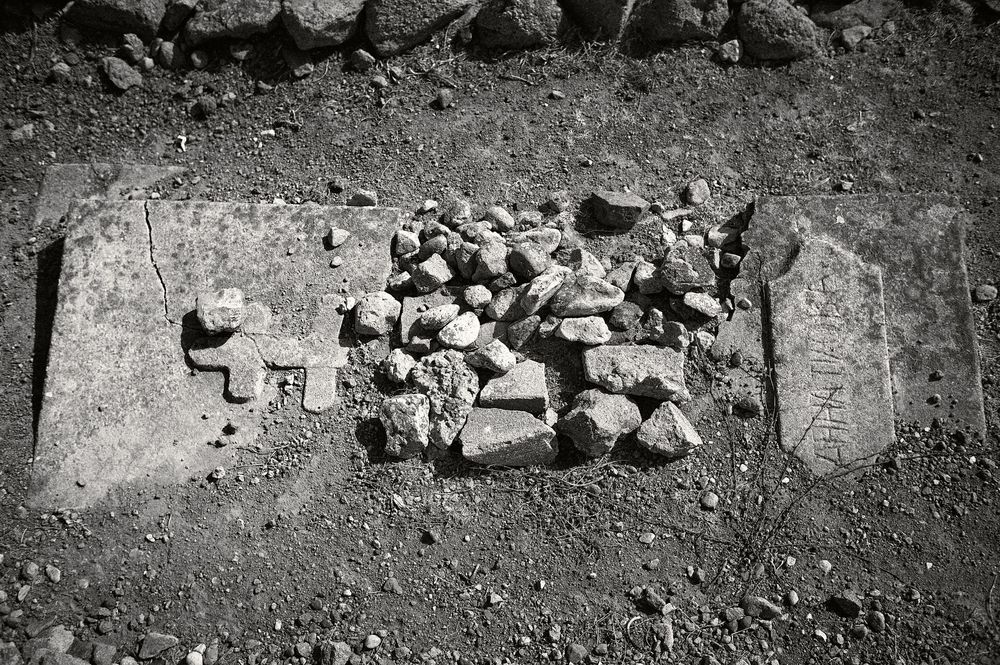 Scattered rocks and debris lie along a rough dirt surface in a barren landscape.
