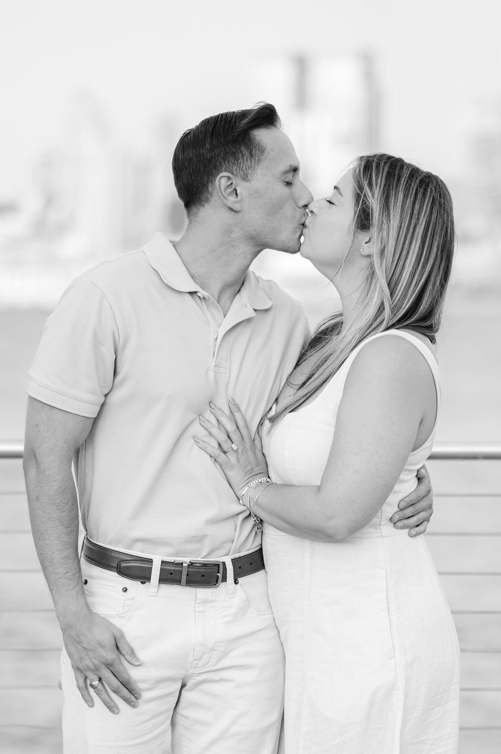 A romantic couple in white outfits shares tender moments in a bright, airy setting.