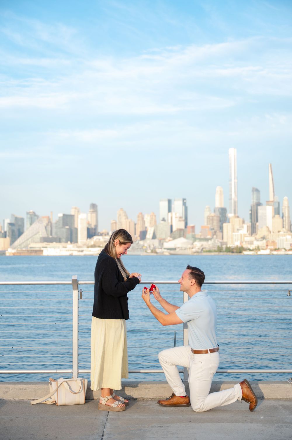 Marriage proposal sequence with New York City skyline backdrop at waterfront.