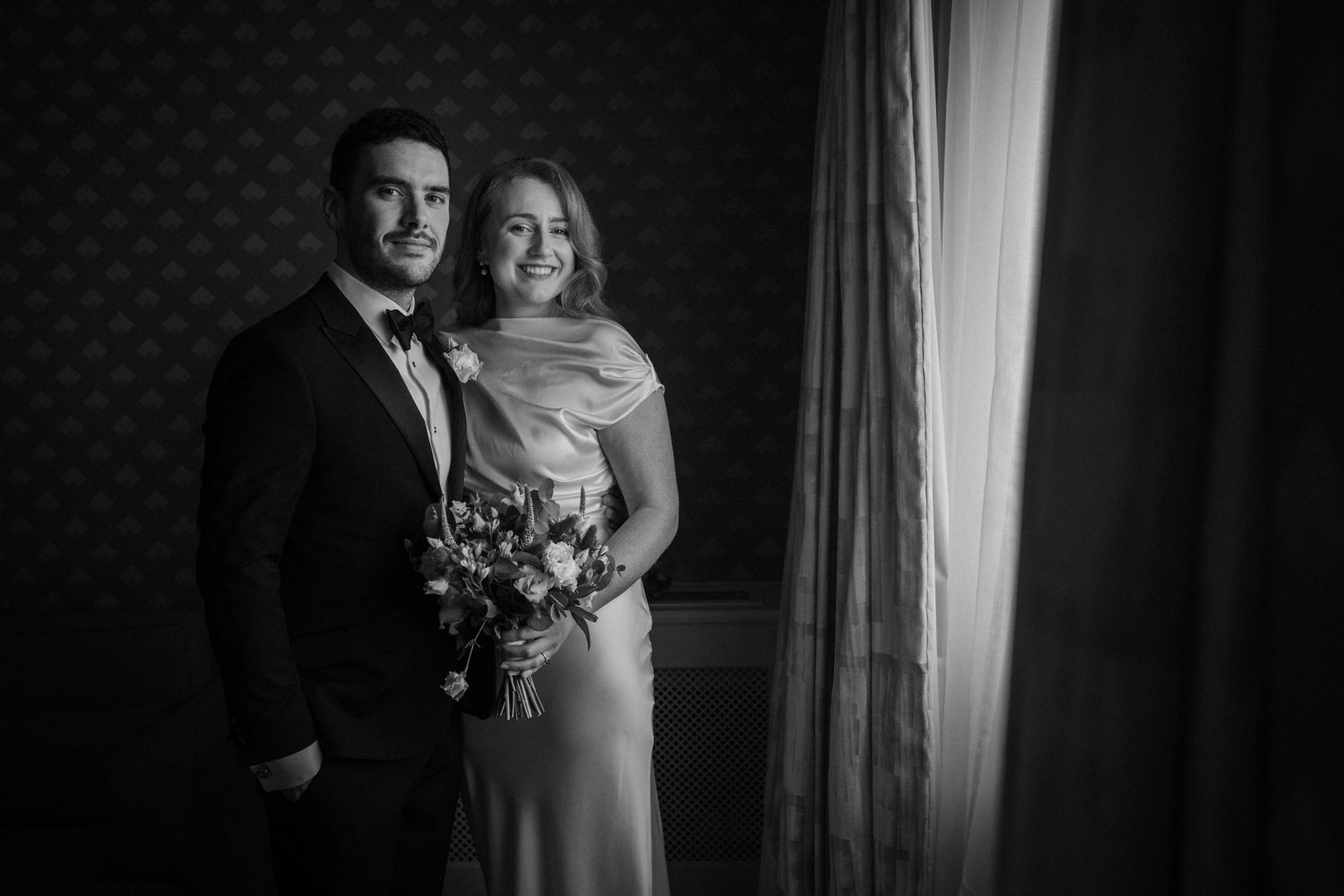 A romantic black and white wedding photo series showing intimate moments between a couple in formal attire.