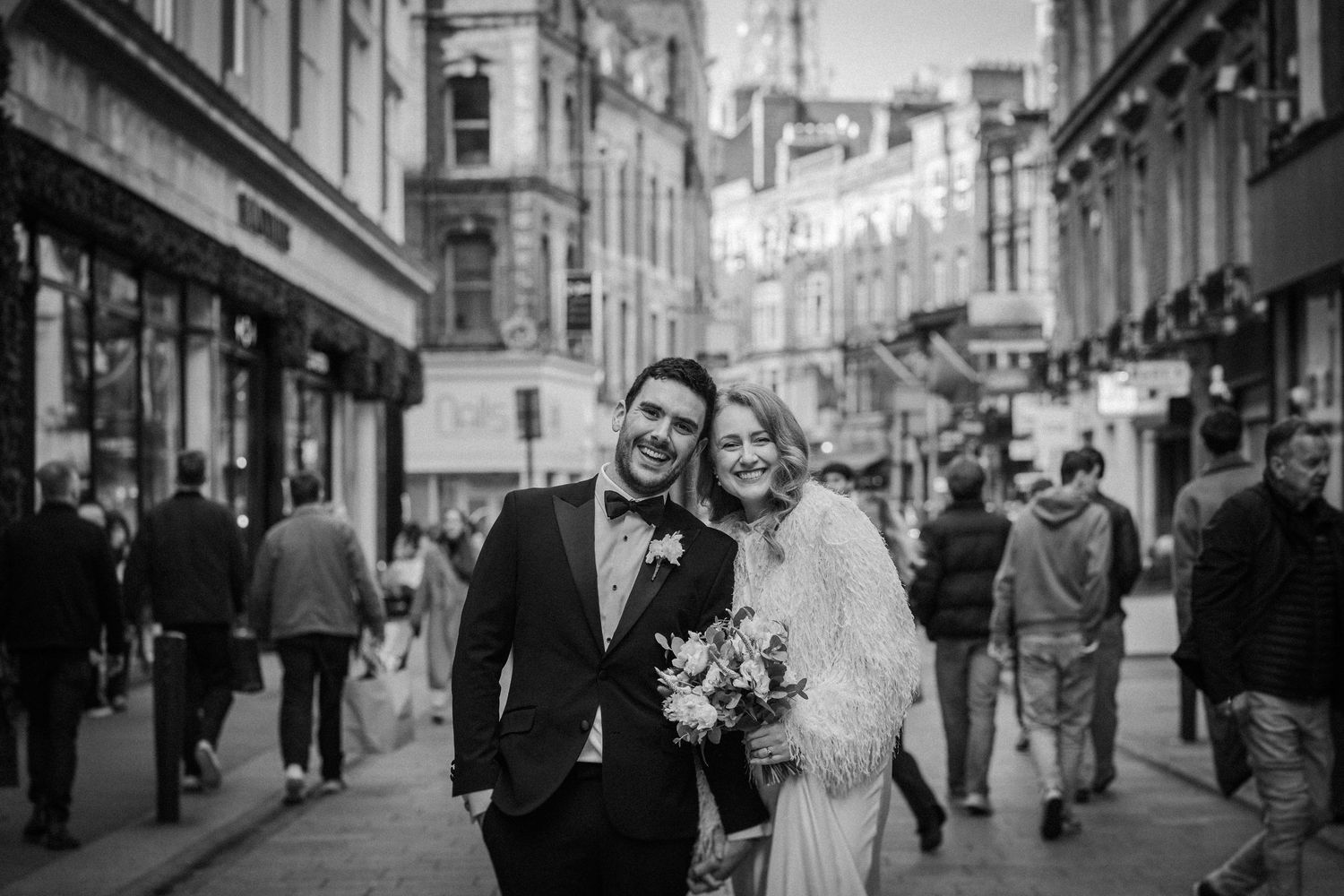 A black and white wedding photo collage showing intimate moments between newlyweds on a city street.