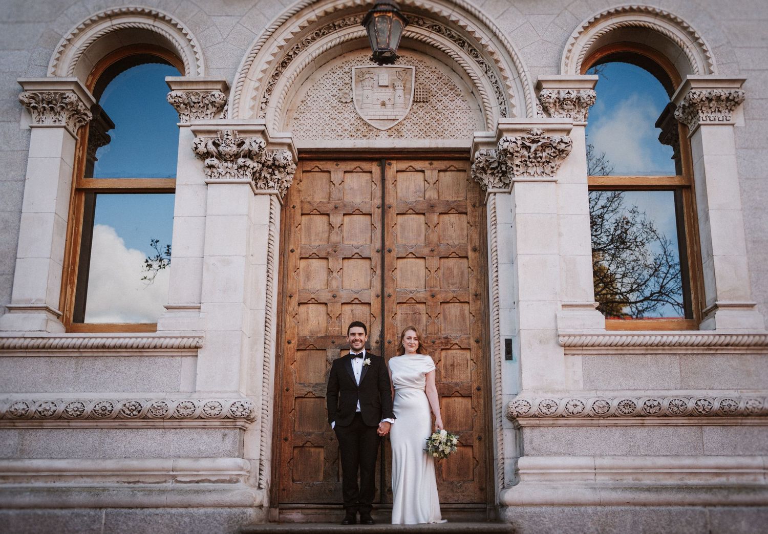 Architectural details of historic stone building with ornate arches and wooden doors.