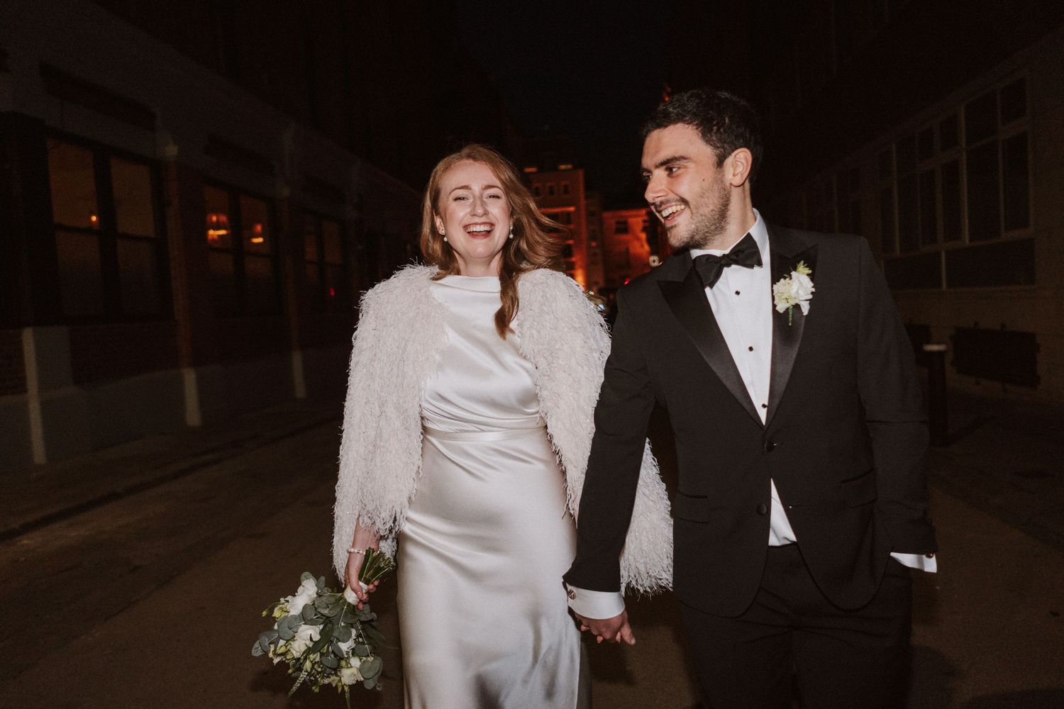 A couple shares a romantic moment during their wedding reception in an elegant indoor venue.