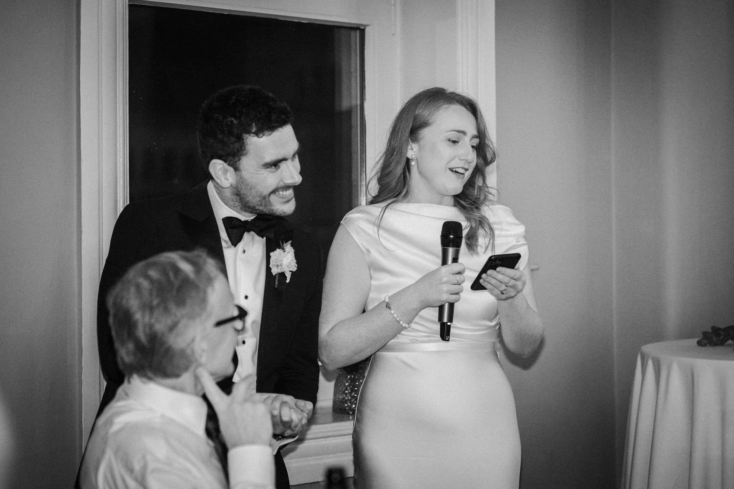 Wedding guests laughing and enjoying themselves during a reception celebration.