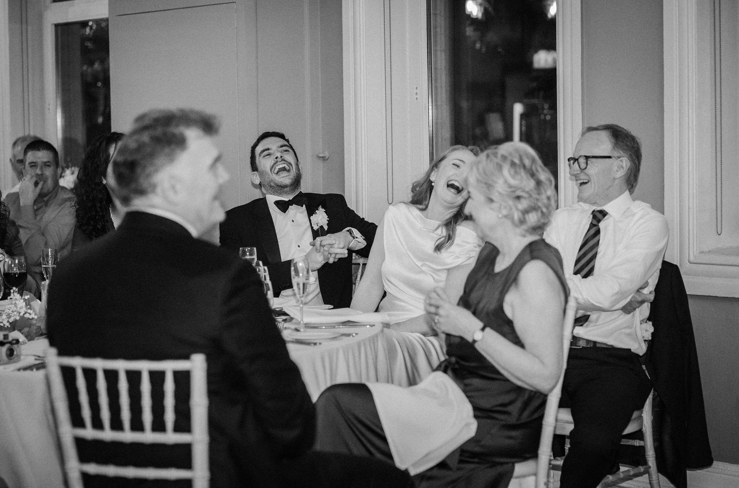 Candid moments of guests sharing laughter and joy during a wedding celebration.