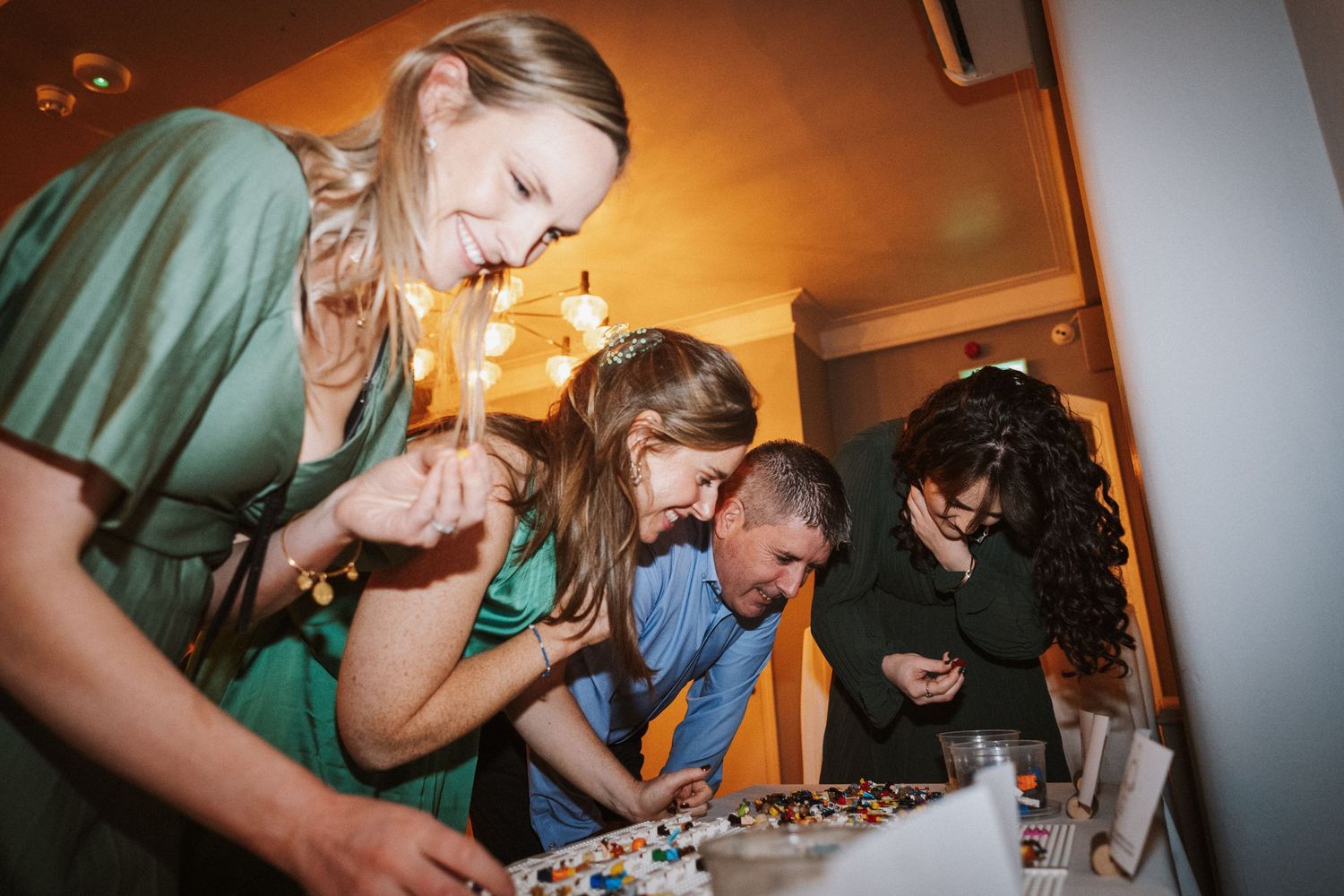 Wedding guests enjoy a lively celebration with drinks and laughter at a reception party.