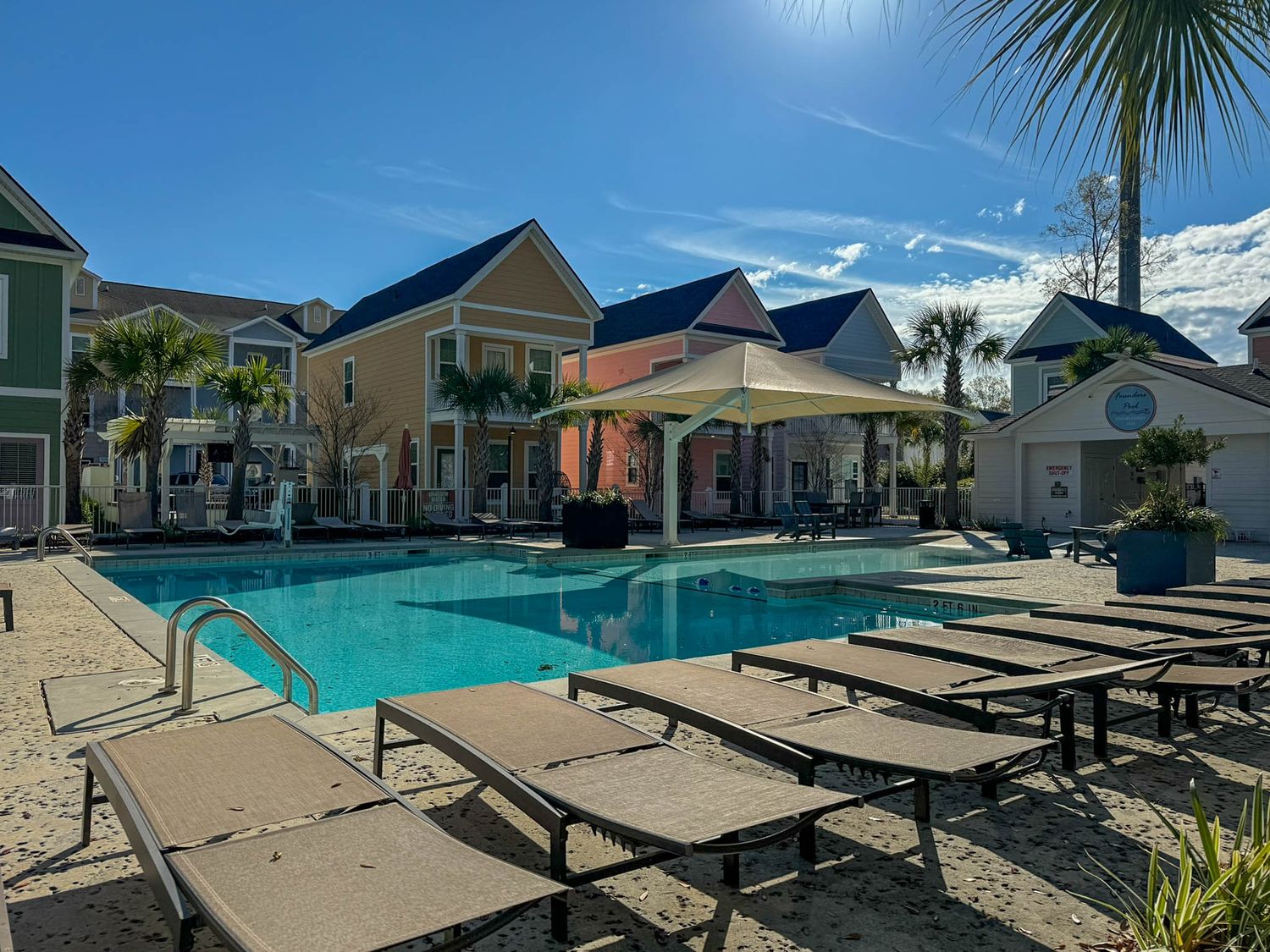Resort-style pool area with lounge chairs and coastal homes in Charleston.