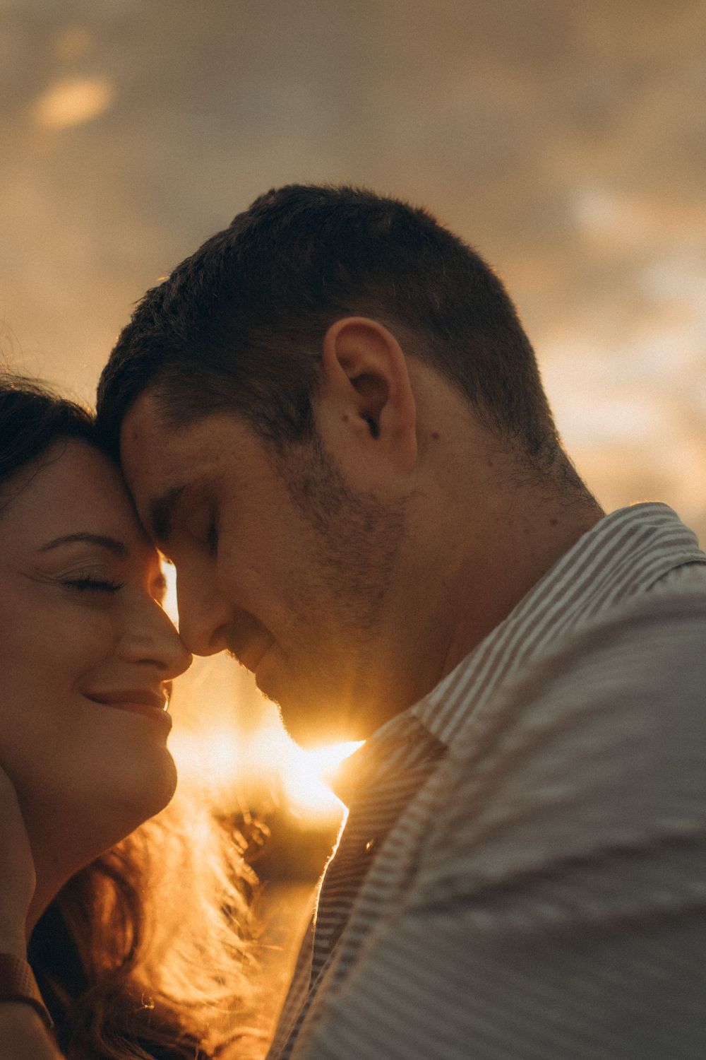 couple touching with their foreheads with dramatic sunset beams in their faces while being captured by Stockholm vacation photographer