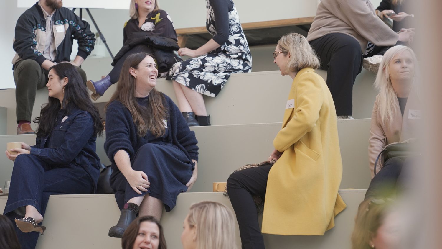 Group of people engaged in casual conversation in an indoor setting.