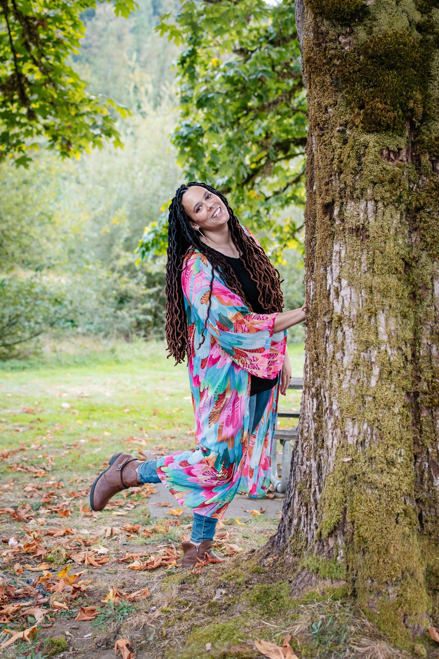 Woman in colorful outfit posing by a tree during outdoor portrait session at Flaming Geyser State Park in Washington.