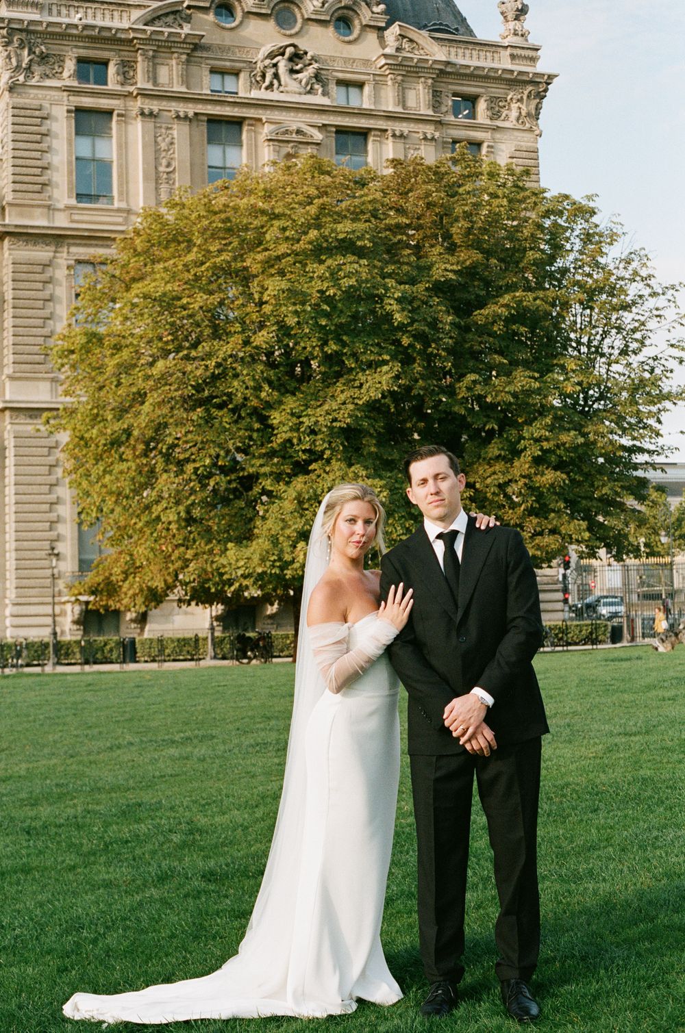 A sequence of four wedding photos shows a couple posing playfully on a grassy lawn near an ornate building. Paris editorial elopement photog