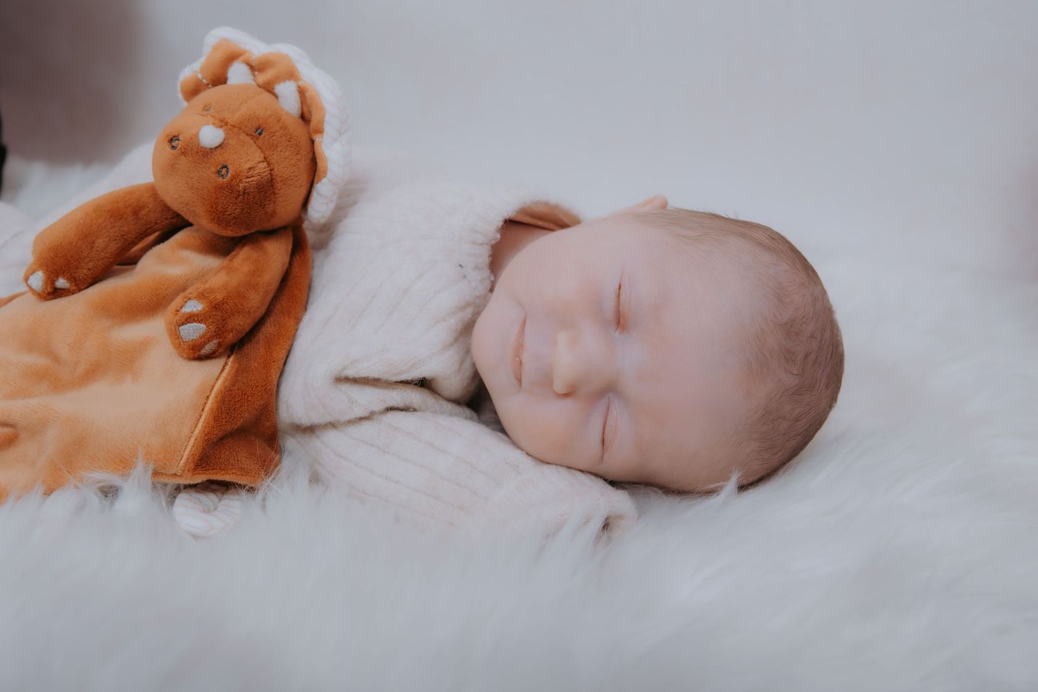 A series of photos showing a sleeping infant on white bedding with a brown plush toy.