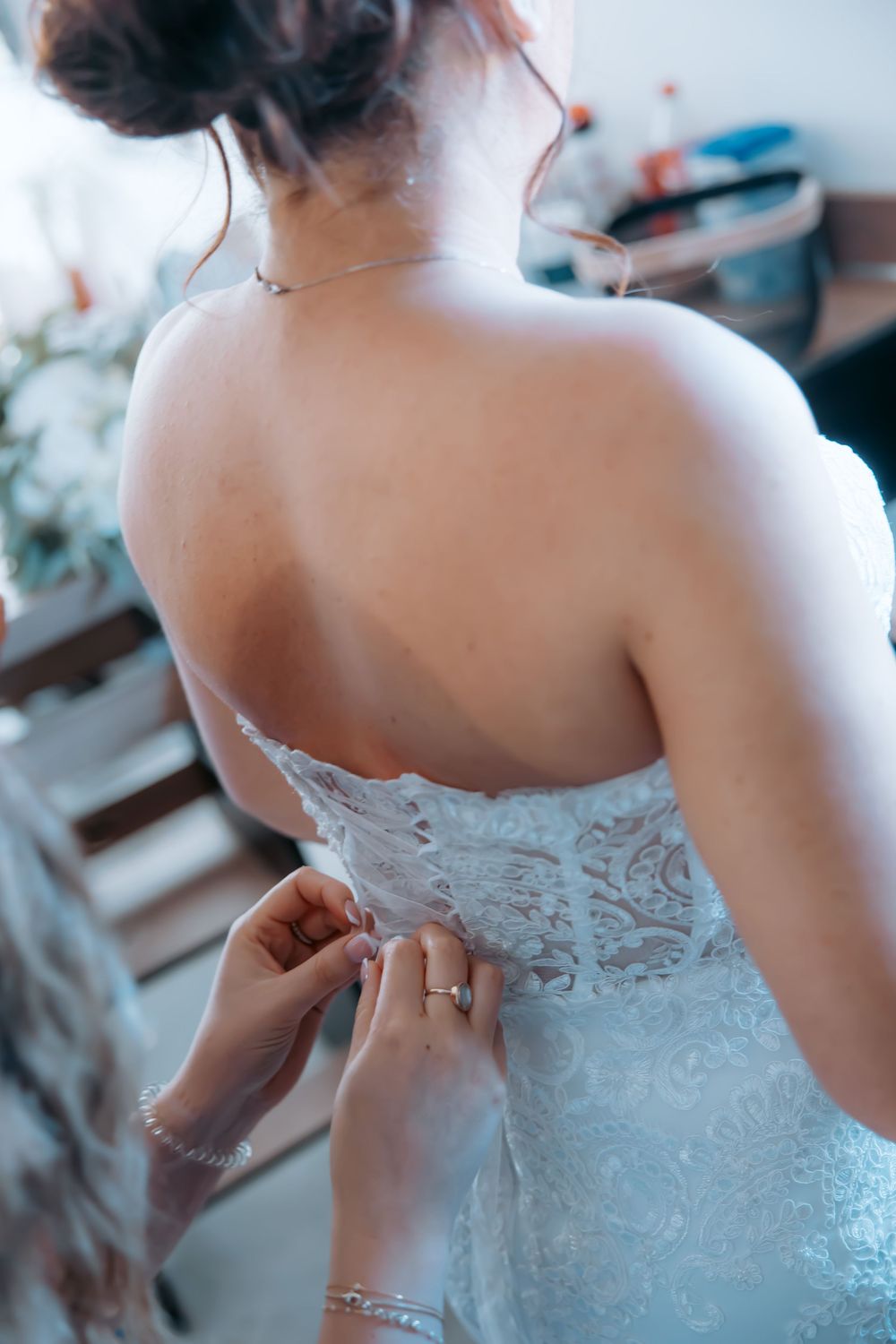 Back view of strapless wedding dress being laced up with intricate details.