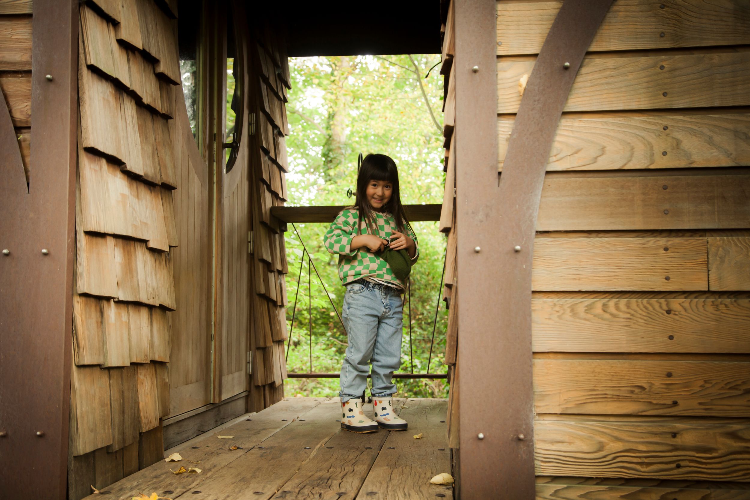 A series of rustic wooden cabins nestled among lush green trees in a tranquil forest setting.
