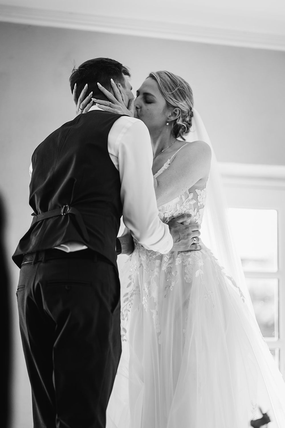 A series of black and white photos showing intimate moments between a couple in wedding attire.