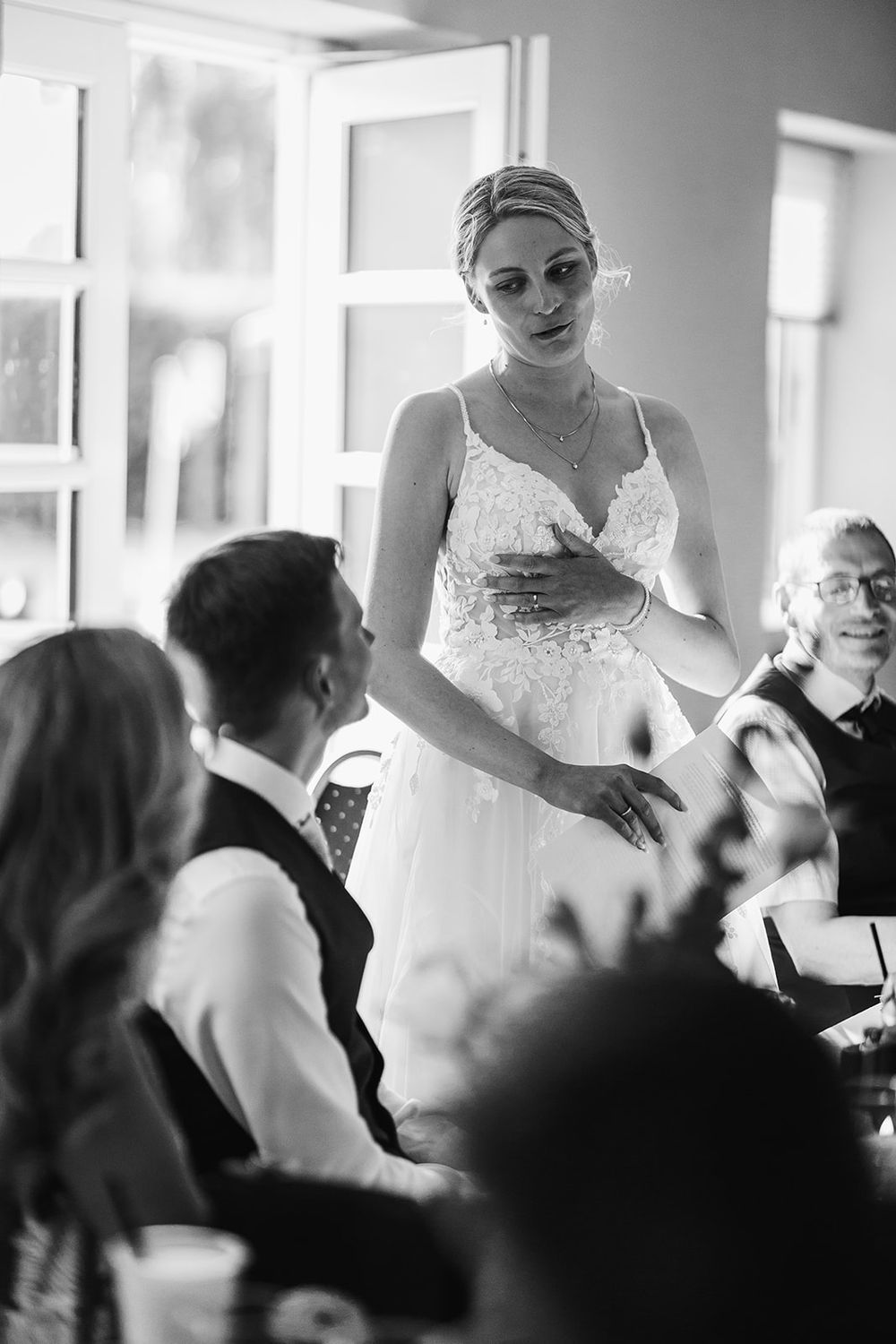 Black and white photo sequence showing a bride getting ready in a dressing room with bridesmaids and helpers.