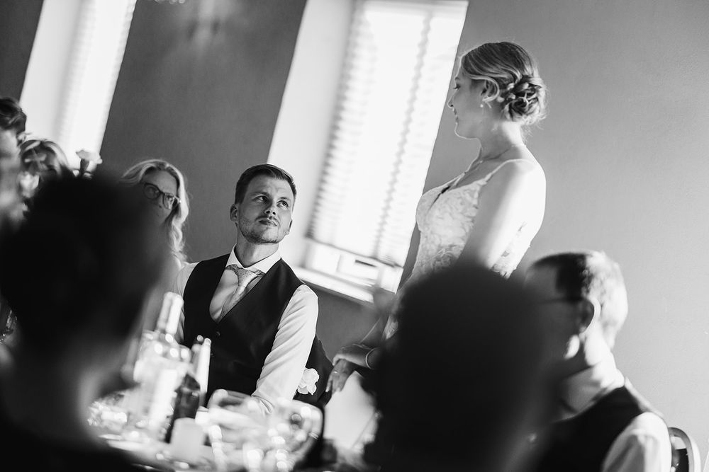 A black and white photo sequence showing candid moments during a wedding reception.